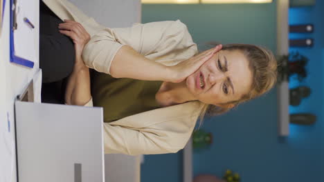Vertical-video-of-Home-office-worker-woman-teeth-aches-and-pains.